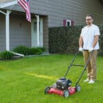 Man portrait mowing the lawn with lawnmower on the house yard